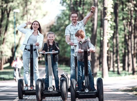 modern family riding an electric mini hoverboard in the Park