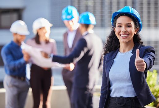 You wont regret your decision. a young businesswoman standing in the city and showing a thumbs up gesture while wearing a hardhat.