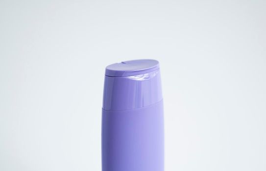 Violet plastic bottle of body care and beauty products. Studio photography of plastic bottle for shampoo, shower gel, creme isolated on white background.