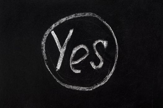 Circled word yes message board school. Decision. Say Yes sign right choice. Correct icon chalk text YES inscription on black chalkboard writing chalk board black background. True. Sign correct symbol