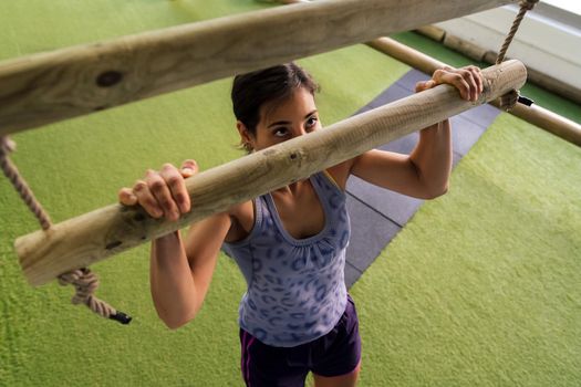 sporty woman strength training doing pull-ups