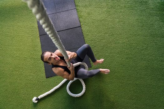 sportsman strength training by climbing a rope