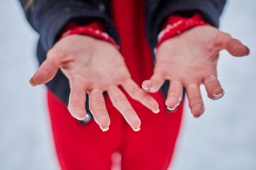 hands of a young woman, close-up, frozen from playing snowballs.