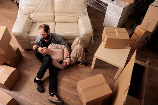 Happy man and woman sitting on living room floor together