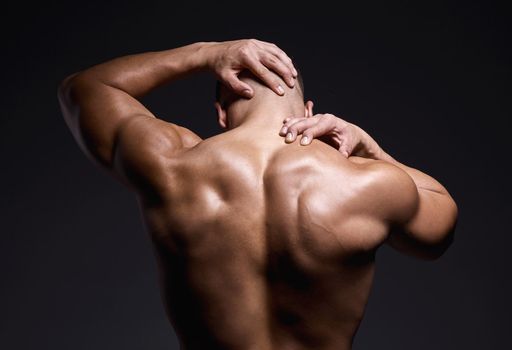 Id never turn my back on a workout. a muscular young man posing against a black background.