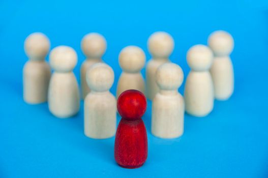 Wooden red doll leading the rest of wooden figure. Leadership and followers concept.