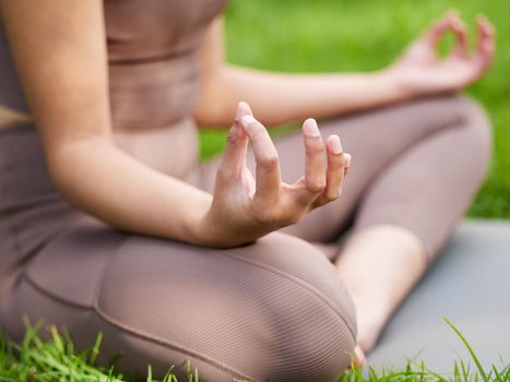 Start your day the calm way. Closeup shot of an unrecognisable woman meditating outdoors.