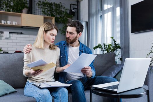 Young family, husband and wife, reviewing their bills, loan and mortgage agreements