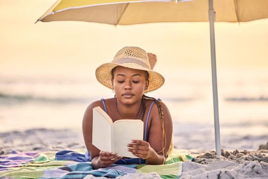A silence of endearment. a beautiful young woman relaxing with a book at the beach.