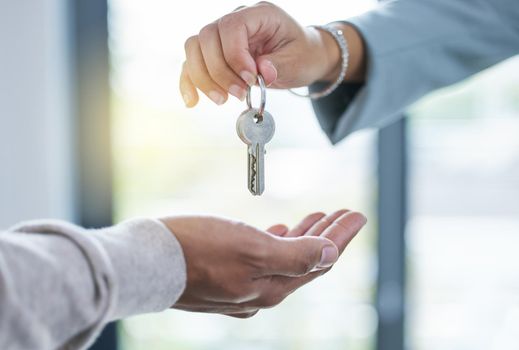 Here are the keys to your new home. an unrecognizable person giving the keys to a house to a buyer.