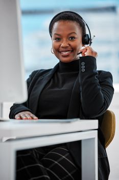 Always have an attitude of gratitude. a young woman using a headset and computer.at work in a modern office.
