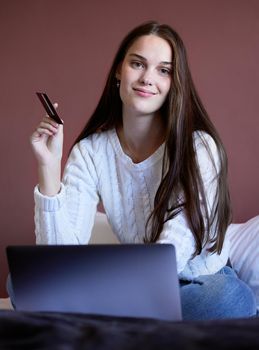 Debt free and happier than ever. a young woman shopping online using her laptop.