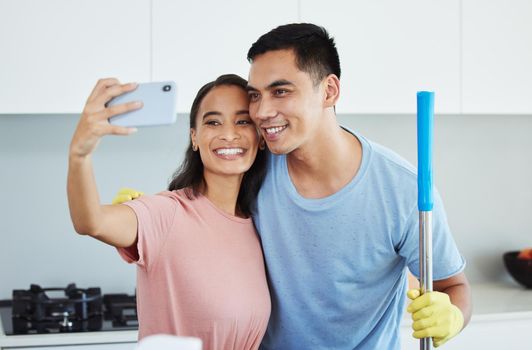 Lets take a photo together. a couple taking a break from cleaning to take a selfie.