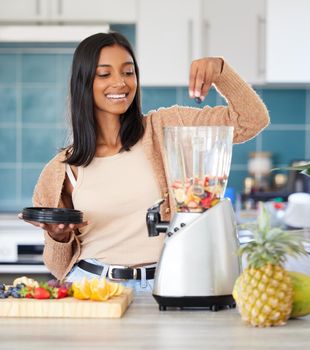 Smoothies provide quick and lasting energy for me. a young woman preparing a healthy smoothie at home.