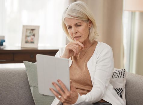 If you dont know get informed. a mature woman using a digital tablet and looking concerned at home.