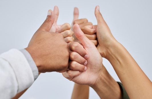 Keep it up and youll continue to soar. Closeup shot of a group of people showing thumbs up together against a white background.