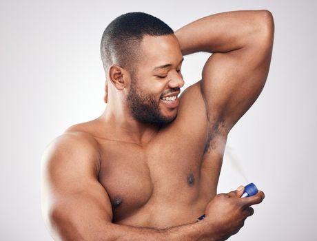 The concept of grooming is proper hygiene. Studio shot of a handsome young man spraying deodorant on his armpit against a white background.