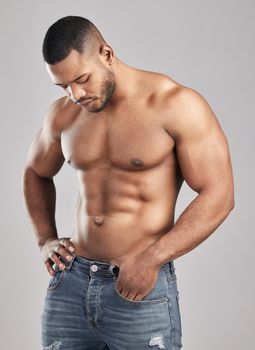 Nobody got in shape by thinking about it. Studio shot of a young muscular man posing against a grey background.