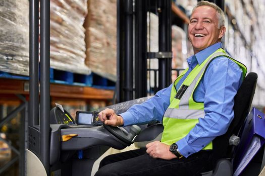 I paid the cost to be the boss. a mature man working on a forklift in a warehouse.