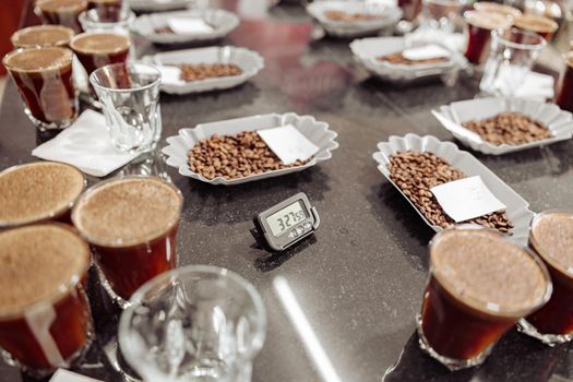 Glasses of coffee and bowls with roasted coffee beans ready for a coffee tasting
