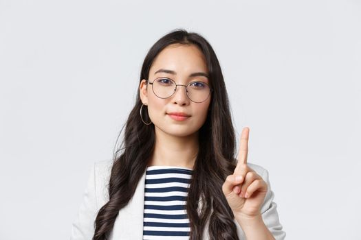 Finance and employment, female successful entrepreneurs concept. Close-up of smart stylish businesswoman, asian manager explain first rule of business, showing one finger and smiling
