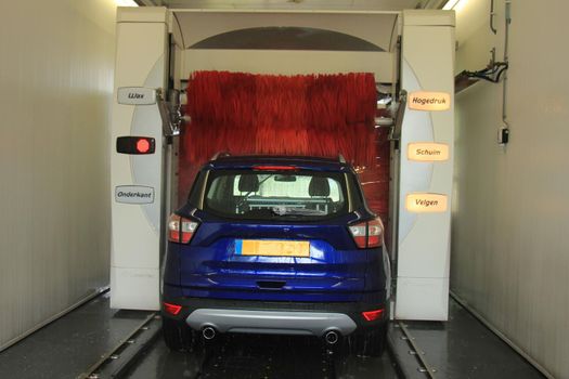 A blue SUV in an automatic car wash