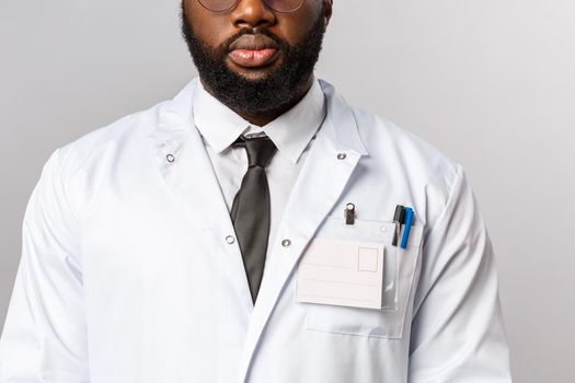 Healthcare, medicine and hospital treatment concept. Cropped shot of bearded african-american doctor in white coat and tie, wear uniform for his night shit at clinic treating patients