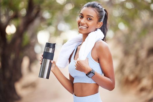 Replace the water you lose through sweating. a young woman taking a break to drink some water during a jog.