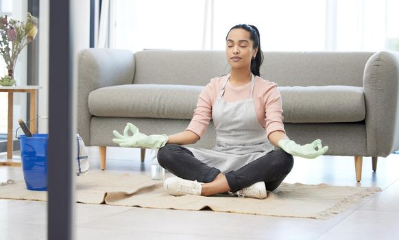 Maybe if I stay calm enough the chores would disappear. a young woman meditating while doing chores at home.