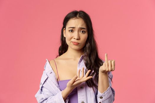 Women, relationship and people concept. Close-up portrait of gloomy complaining asian girl showing finger without ring, smirk and frowning upset, want get married, why boyfriend dont make proposal