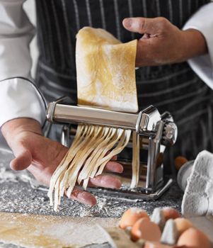Freshly made pasta for your pleasure. an unrecognisable man preparing freshly made pasta.