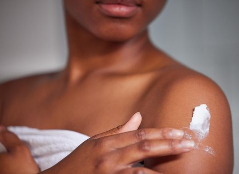 Keeping my skin smooth and suuple. a woman applying lotion to her body.