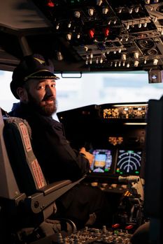 Portrait of caucasian captain using cockpit dashboard command