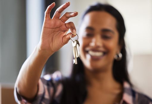 To some moving house is just another habit. a young woman showing the keys to her new home.