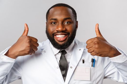 Healthcare, medicine and hospital treatment concept. Close-up portrait of satisfied, happy african-american doctor, physician assure patient do check-up this clinic, best hospital, recommending