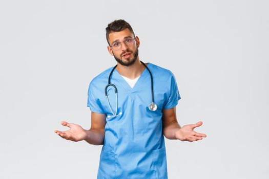 Healthcare workers, medicine, covid-19 and pandemic self-quarantine concept. Determined young professional physician, doctor in ER wearing scrubs, spread hands sideways, explain prescription