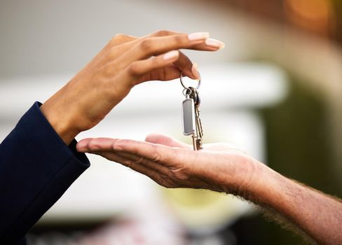 Handing over the keys is the last thing to do. an unrecognizable female real estate agent handing the keys of a newly purchased home to her male client outside.