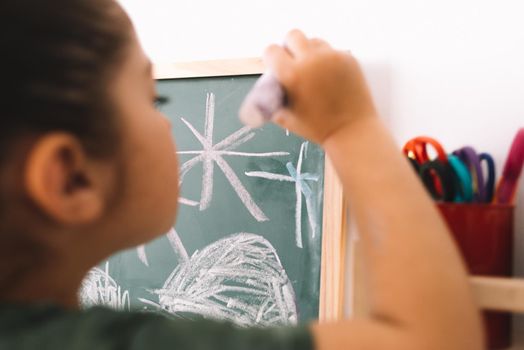 little girl drawing on a chalkboard