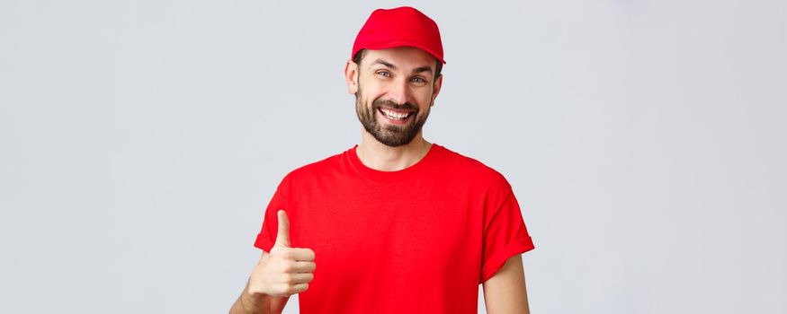 Online shopping, delivery during quarantine and takeaway concept. Friendly, cheerful courier in red cap and t-shirt uniform, encourage make internet orders, thumb-up in approval or recommendation