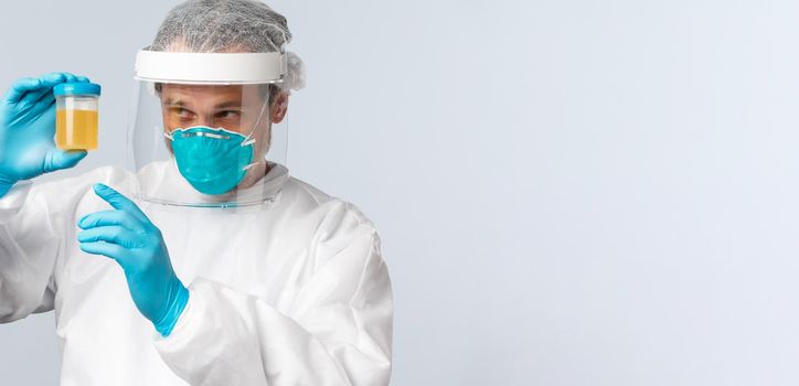 Covid-19, preventing virus, healthcare workers and vaccination concept. Medical employee, nurse or doctor in personal protective equipment examine urine sample of patient
