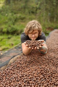 Happy male traveler holding coffee in natural drying process