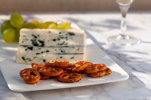 Gorgonzola cheese served outdoors with green grapes and snacks
