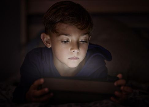 Childlike faith is all the we never knew we needed. adorable little boy using a digital tablet at night.