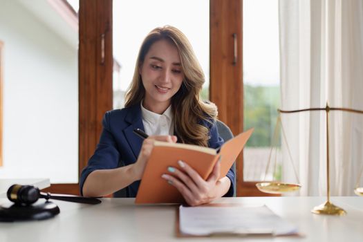 Lawyer business woman reading law book and agreement contract.
