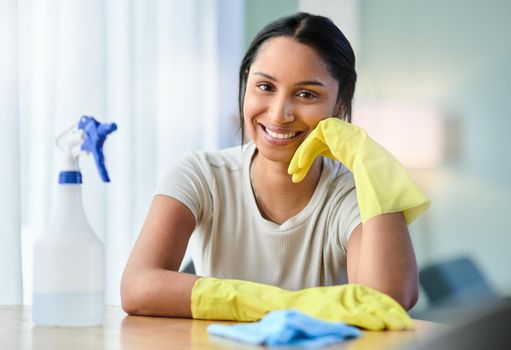 A dirty house just means youre living life right. a young woman wearing gloves at home.
