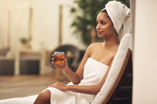 Treat yourself to a little luxury, rest and relaxation. a woman drinking tea while enjoying a spa day.