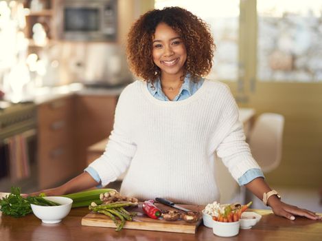 Healthy eating done right. Portrait of a happy young woman preparing a healthy meal at home.