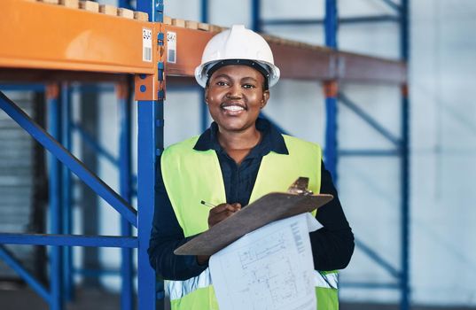 Leading by example for other women out there. an attractive young contractor standing in the warehouse and holding a clipboard.