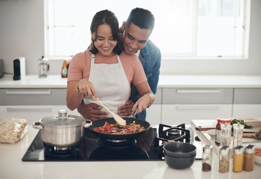 Good food keeps them happy. a young couple cooking together at home.