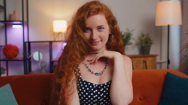 Close-up of happy beautiful teenager redhead freckles woman smiling looking at camera at home